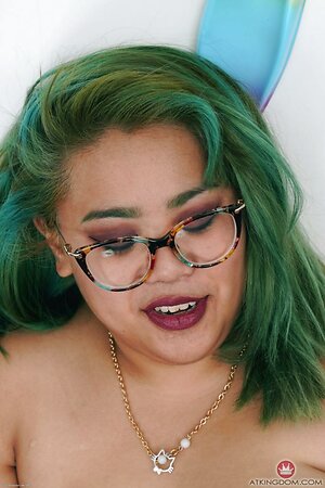 Green-haired Asian MILF with lovely face poses fully nude near wall